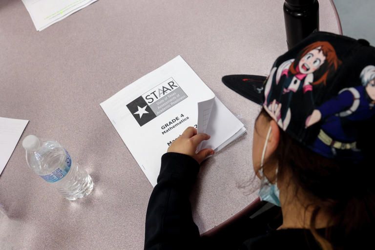 A fourth-grader flips open her STAAR mathematics booklet to go over her answers during class at Heritage Elementary School in San Antonio in this 2022 photo. Parents and teachers are criticizing the Texas Education Agency’s decision to let computers grade students’ STAAR essay test questions.