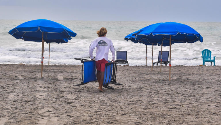 An employee of Rosenberry's Rentals sets up chairs and umbrellas Tuesday morning on the beach, just south of the Westgate Cocoa Beach Pier in Cocoa Beach. A new survey of visitors to the Space Coast found that 68% of visitors to the Space Coast cite going to the beach as one of their activities while here.