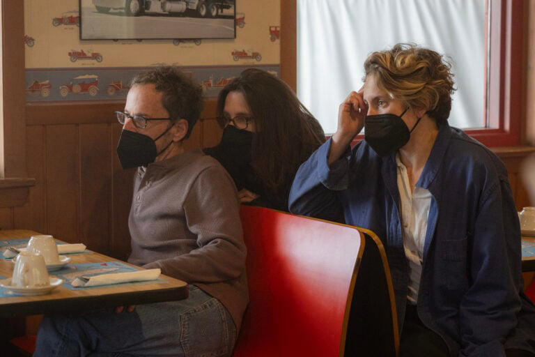 (L-R) Director/writer/producer Ethan Coen, writer/producer Tricia Cooke and director of photography Ari Wegner on the set of Drive-Away Dolls , a Focus Features release. Photo Credit: Wilson Webb / Working Title / Focus Features.