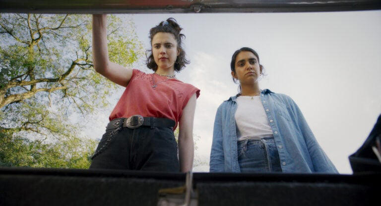 (L to R) Margaret Qualley as “Jamie” and Geraldine Viswanathan as “Marian” in director Ethan Coen’s DRIVE-AWAY DOLLS, a Focus Features release. Credit: Courtesy of Working Title / Focus Features
