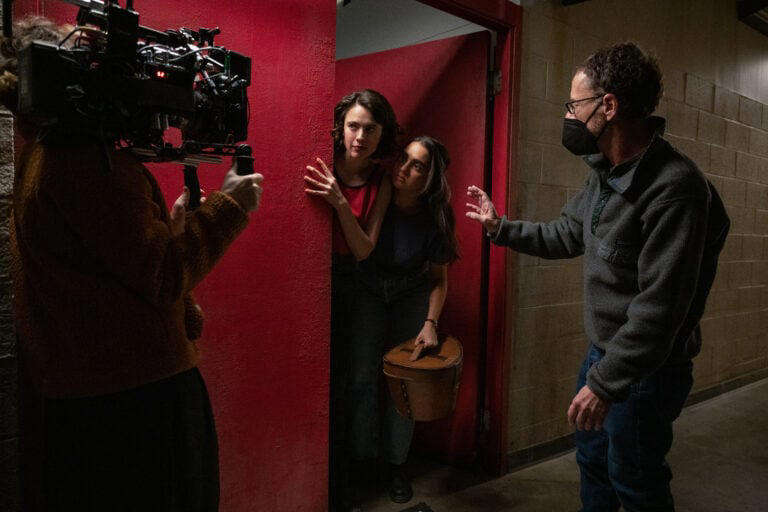 (L to R) Actor Margaret Qualley, actor Geraldine Viswanathan and director/writer/producer Ethan Coen on the set of DRIVE-AWAY DOLLS, a Focus Features release. Credit: Wilson Webb / Working Title / Focus Features