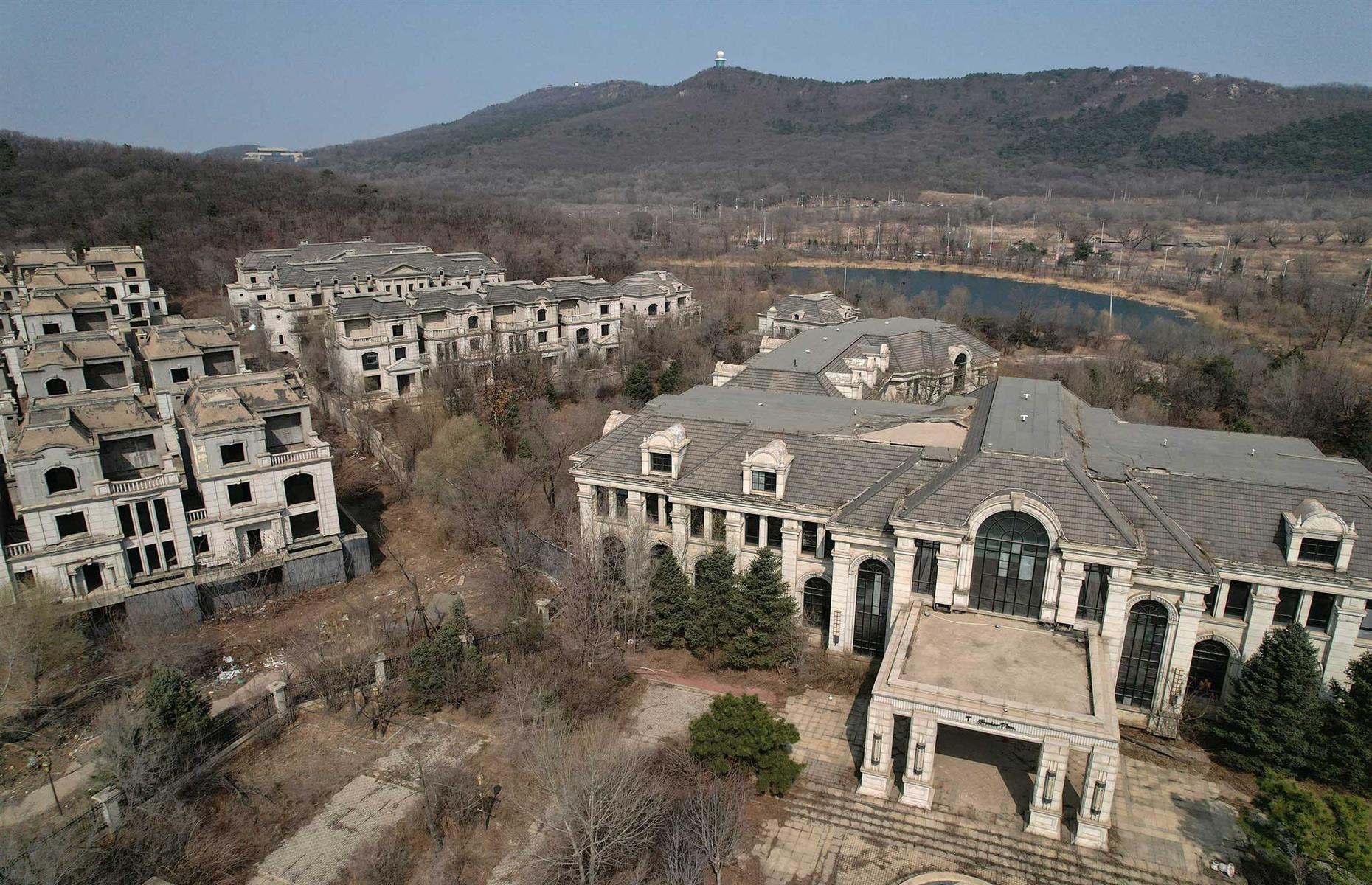 <p>In 2010, Chinese property giant Greenland Group began building State Guest Mansions, an upmarket neighborhood of 260 lavish homes complete with luxury amenities, designed for China's millionaires. </p>  <p>But just two years later, the elaborate plans were shelved and these European-style châteaux were left to rot. “These [homes] would have sold for millions – but the rich haven’t even bought one of them,” a local farmer told <a href="https://hongkongfp.com/2023/07/23/in-northeastern-china-farmers-reclaim-ghost-town-of-mansions-abandoned-by-housing-developer/"><em>AFP</em></a>. “They weren’t built for ordinary people.”</p>