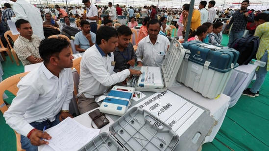 Election staff check the Electronic Voting Machines (EVM) at a polling station ahead of the first phase of polling on Friday.