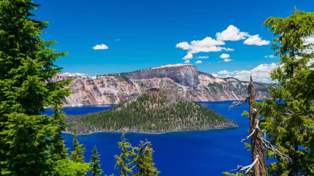 <p>Crater Lake is home to two small islands that have managed to rise up from the depths. Wizard Island is the larger of the two and the only one you can reach (by tour boat) and explore.</p><p>This cinder cone island sits near the western shore and has a 2.4-mile trail that leads to the top of the cone, which stands 750 feet above the lake’s surface.</p>