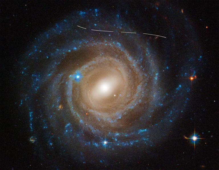 Beautiful photo of galaxy UGC 12158 gets photobombed by an asteroid