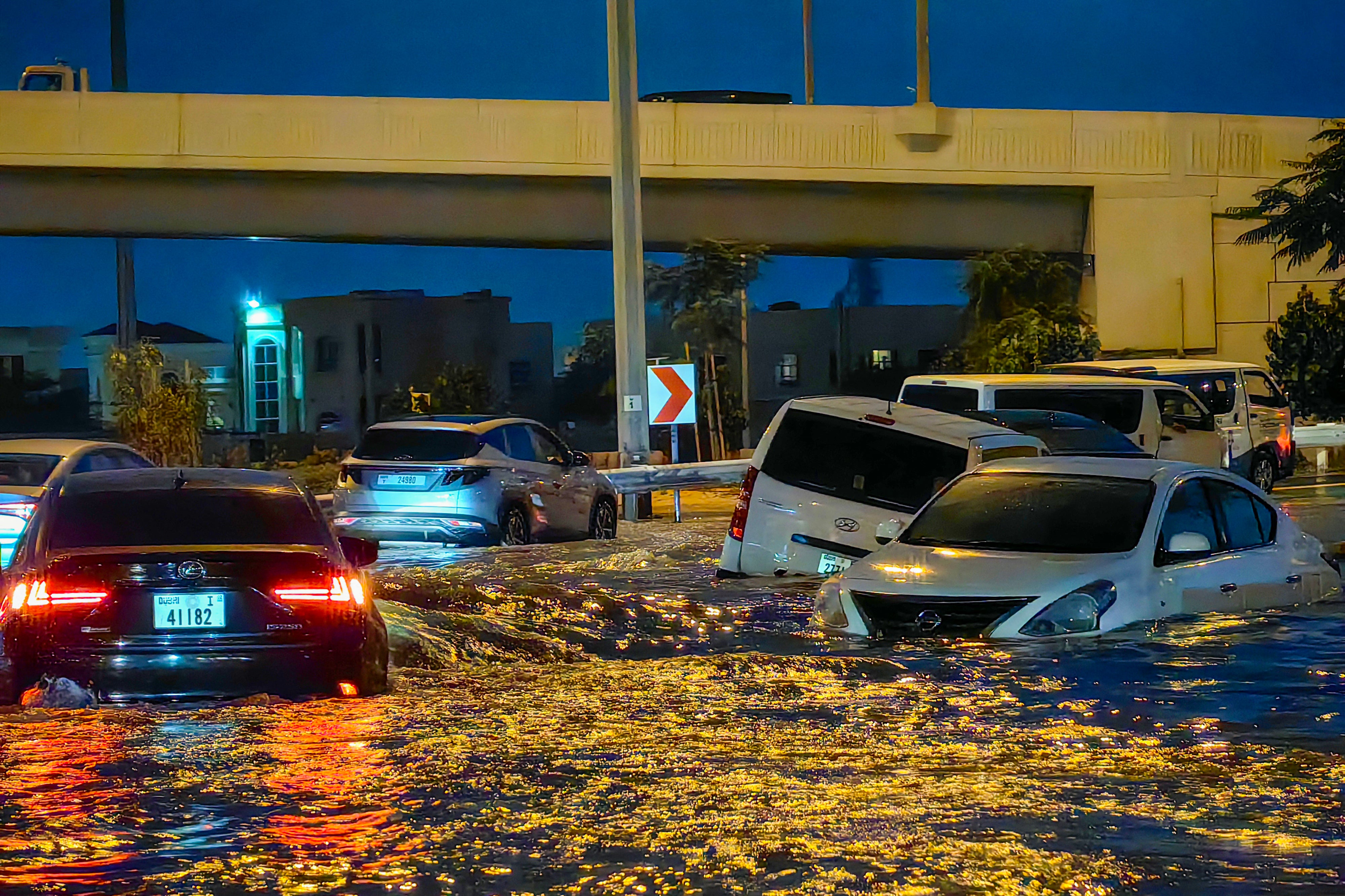 dubai struggles to return to normality after devastating floods as cars remain submerged in water