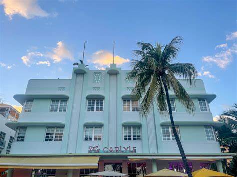 The Carlyle Hotel is an iconic Art Deco landmark on Ocean Drive, known for its distinctive pink facade and elegant architecture. Built in 1939, it exudes old-world charm and sophistication, with its sleek lines, decorative motifs, and tropical landscaping.]]>