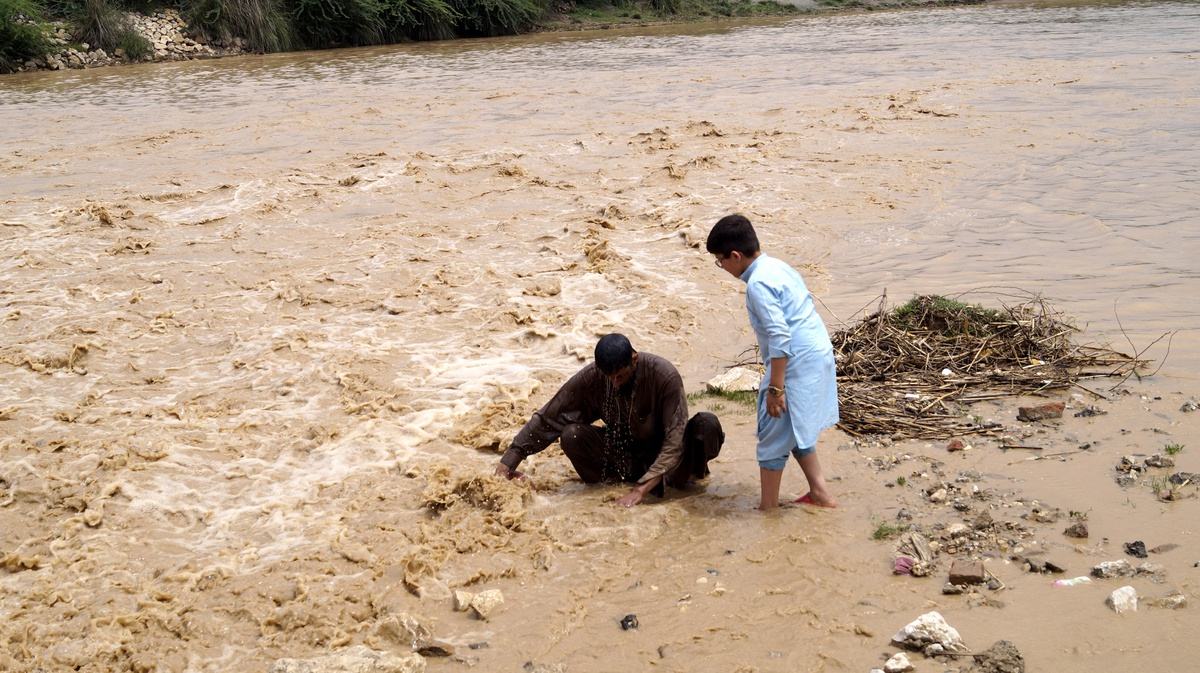 Dos personas en una zona inundada en el distrito de Dera Ismail Khan, este viernes en Pakistán. La zona suroeste del país ha estado afectada por fuertes lluvias que han causado la muerte de 36 personas y han provocado 46 heridos, según las autoridades provinciales. EFE/SAOOD REHMAN