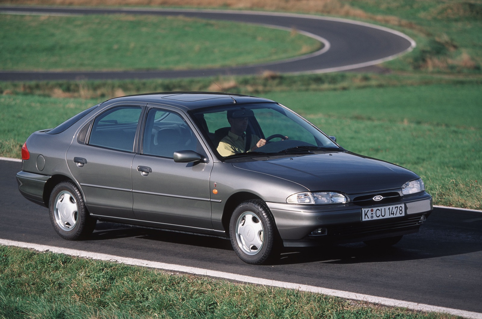 <p>Introduced in <strong>1992</strong>, and celebrated as a world car, the first-generation Mondeo played a significant role in propelling Ford of Europe to stardom during the 1990s. In the UK, it helped Ford outsell Vauxhall, its arch rival. It later became the <strong>Contour</strong> in America, and it spawned the <strong>Mercury Mystique</strong>. <strong>118,040 units</strong> of the Mondeo were sold in the UK in <strong>1995</strong>, a figure that placed it in third place behind the Escort and the Fiesta, and comfortably ahead of the Vauxhall Cavalier (<strong>73,978 sales</strong>). It was a company car, a family car, and a sports car when Ford added V6-powered ST-branded models to the line-up in the late 1990s.</p><p>Demand for the Mondeo gradually dropped during the 2000s; sales totalled <strong>57,589 units</strong> in 2005. It lost its world car vocation when Ford chose not to replace the Contour, but the Mondeo returned to the United States as the Fusion in 2012. Designing one saloon for two markets made sense, because sales were too low in each to justify making a country-specific car. By 2017, the Mondeo had fallen off the UK’s top-10 list, and the Fusion lingered in 19<sup>th</sup> spot with 209,623 sales, far behind its main rivals.</p>