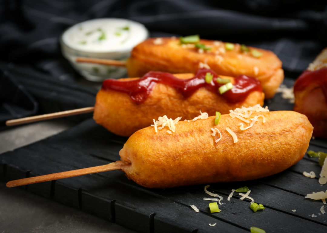 <p>Corn dogs, hot dogs on a stick coated entirely with fried sweet cornbread, are a sweet and savory on-the-go snack typically found at American recreational locales like theme parks, fairs, and beachside boardwalks. Like a few other items on this list, the origins of the corn dog are widely disputed. Some claim it first appeared at a <a href="https://texashillcountry.com/corn-dog-invented-park/">Texas state fair in 1942</a>, and others claim a version of a corn dog called a Pronto Pup <a href="https://www.opb.org/article/2022/07/16/first-corn-dog-made-in-oregon-pronto-pup/">appeared on Labor Day 1939</a> in Portland, Oregon. Either way, this is a one-of-a-kind iteration of a hot dog that might look strange to anyone outside the U.S.</p>