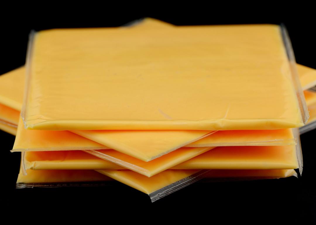 <p>As if the name doesn't say it all, American cheese is a very American delicacy that comes in convenient little plastic-wrapped squares and is not particularly well respected in the rest of the world. It's a processed cheese made from cheddar and, like Cheez Whiz, was <a href="https://www.thrillist.com/eat/nation/history-of-american-cheese-underrated">developed when</a> Kraft patented their way of processing cheese. Also known as yellow cheese, it's a beloved choice for American staples like grilled cheese and cheeseburgers.</p>