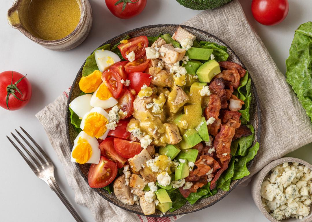 <p>The Cobb salad, a giant salad containing practically the whole food pyramid, consists of chopped iceberg lettuce or romaine, bacon, chicken breast, tomato, hard-boiled eggs, avocado, cheese (generally blue), chives, and is tossed with a red wine vinaigrette. The salad <a href="https://ice.edu/blog/rediscovering-american-classic-cobb-salad">was born in 1937</a> at the Brown Derby restaurant in Hollywood by owner Robert Howard Cobb. Though the ingredients are not particularly odd, the salad is high in calories and salt, which may be considered unhealthy to diners from other countries.</p>
