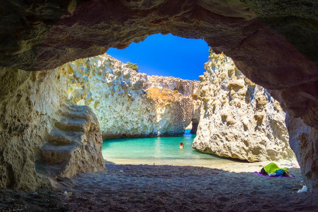 this might be the most photogenic island in greece — with a moon-like landscape, gorgeous sea caves, and some of the bluest water you've ever seen
