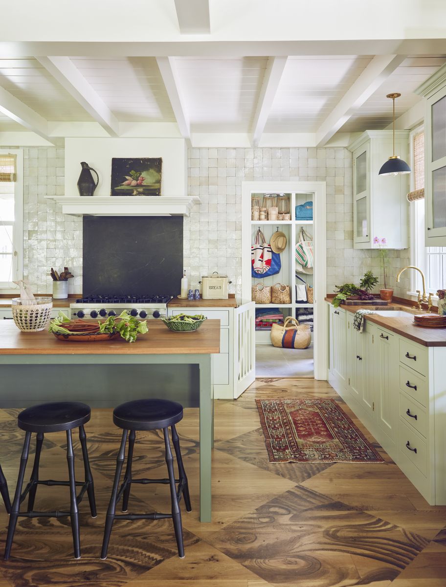 <p>In <a href="https://www.veranda.com/decorating-ideas/house-tours/a42829524/veronica-swanson-beard-nantucket-house/">this Nantucket cottage</a>'s custom Plain English kitchen, creamy countertops are topped with rustic wood counters. Pearly Moroccan wall tiles, similar in color to the cabinetry, are laid to the ceiling without grout to give the walls more rhythm. A slate backsplash contrasts the warm white. The work table base is painted a pretty green and looks like a piece of furniture. Pendant lighting, <a href="https://www.hectorfinch.com/">Hector Finch</a></p>