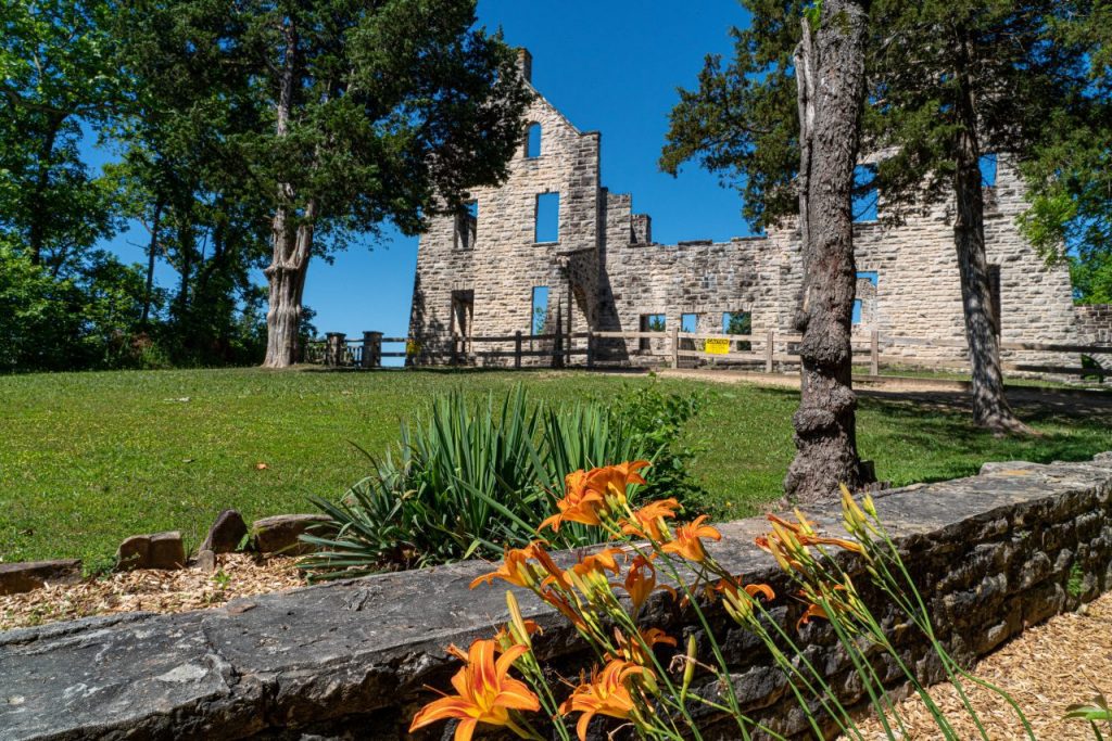 <p>At the top of the list and the top of the hill sits the Ha Ha Tonka Castle Ruins. Kansas City businessman, Robert McClure Snyder, started construction on the castle in 1905, only to die in a car crash in 1906. His sons, Robert Jr., LeRoy, and Kenneth, completed the project in the early 1920s, just in time for the stock market crash. It struggled as a hotel during the Great Depression, only to burn to the ground in 1942. Initially designed as a 16th-century European fairy tale, these buildings more closely resemble a turn of the century American gothic.</p> <p>Today, visitors can see the crumbling walls of the castle, water tower, and stables. For a moment, you could imagine that you’re in Europe looking at an old ruin set high above the Rhine. Interpretive signs tell you about the construction, operation, and demise of this historic structure. Also not to be missed are the sweeping views of the Niagara Arm of the Lake of the Ozarks. Since the 250′ cliffs face west, this location is home to some of the best sunsets in the state.</p>