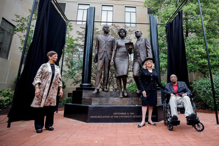 Carmen Smith, Henrie Monteith Treadwell and James Solomon Jr. pose in front of the new desegregation monument at The University of South Carolina. The monument, which was unveiled on Friday, April 19, 2024, was created from a photograph showing Treadwell, Solomon and Robert Anderson as the first Black students admitted to the university. Carmen Smith is Robert Andersons sister.