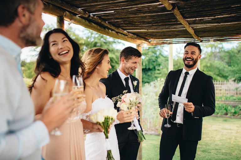 Best man giving speech to newlywed couple at wedding reception