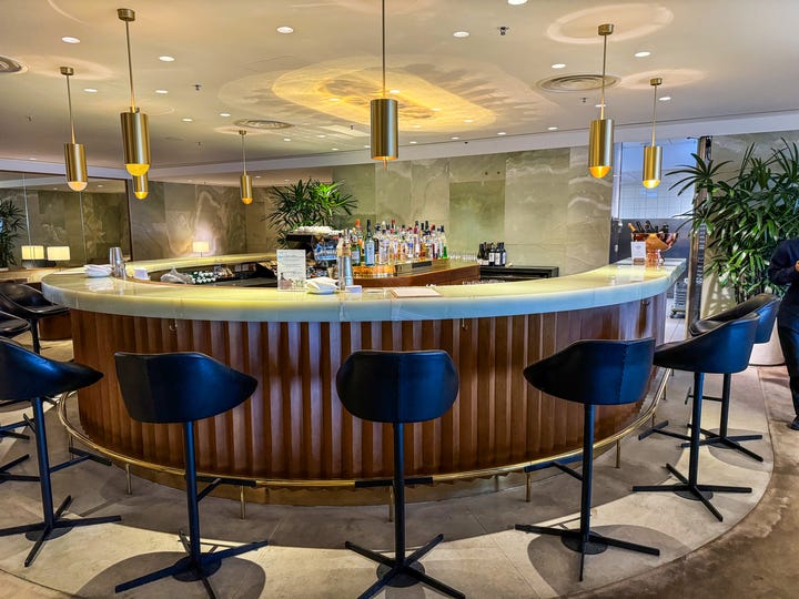 <p>The bar served specialty coffee drinks, sodas, waters, and an abundance of cocktails, wines, and spirits.</p><p>Some of the cocktails were from the Rosewood Hong Kong collaboration with its bar, DarkSide, which is touted as one of the <a href="https://www.rosewoodhotels.com/en/hong-kong/dining/darkside">50 best bars in Asia</a>.</p><p>I ordered coffee and a few glasses of wine while I was waiting for my flight. The bartender was super attentive.</p><p>Since the lounge is so exclusive, there wasn't a wait for drinks like you often experience in other <a href="https://www.businessinsider.com/first-time-in-airport-lounge-surprising-things-chase-sapphire-2024-2">airport lounges</a>. The service also felt more personalized.</p>