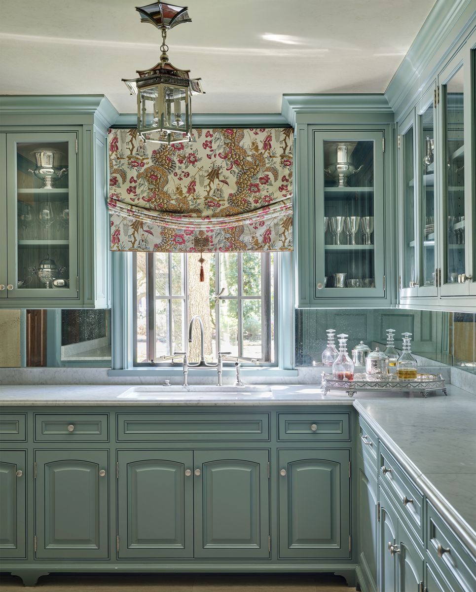 <p>The traditi0nal butler’s pantry in <a href="https://www.veranda.com/decorating-ideas/house-tours/a43474734/charlotte-moss-houston-home-tour/">this 1920s Tudor in Houston designed by Charlotte Moss</a> is painted <a href="https://go.redirectingat.com?id=74968X1553576&url=https%3A%2F%2Fwww.benjaminmoore.com%2Fen-us%2Fpaint-colors%2Fcolor%2F691%2Fdartsmouth-green&sref=https%3A%2F%2Fwww.veranda.com%2Fdecorating-ideas%2Fg35091957%2Fkitchen-cabinet-ideas%2F">Dartsmouth Green (Benjamin Moore)</a> with classic satin nickel hardware. Glass-front upper cabinets display glassware and silver pieces. This smaller space in a home is an ideal place to experiment with color and pattern.</p>