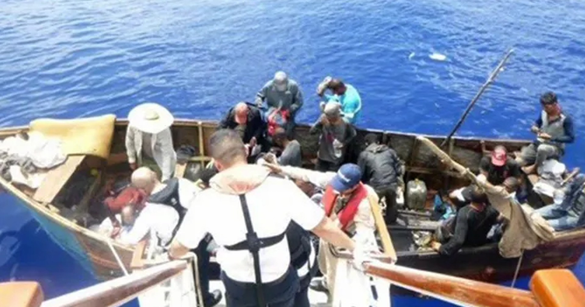 cruise ship rescues migrants on small wooden boat signaling for help