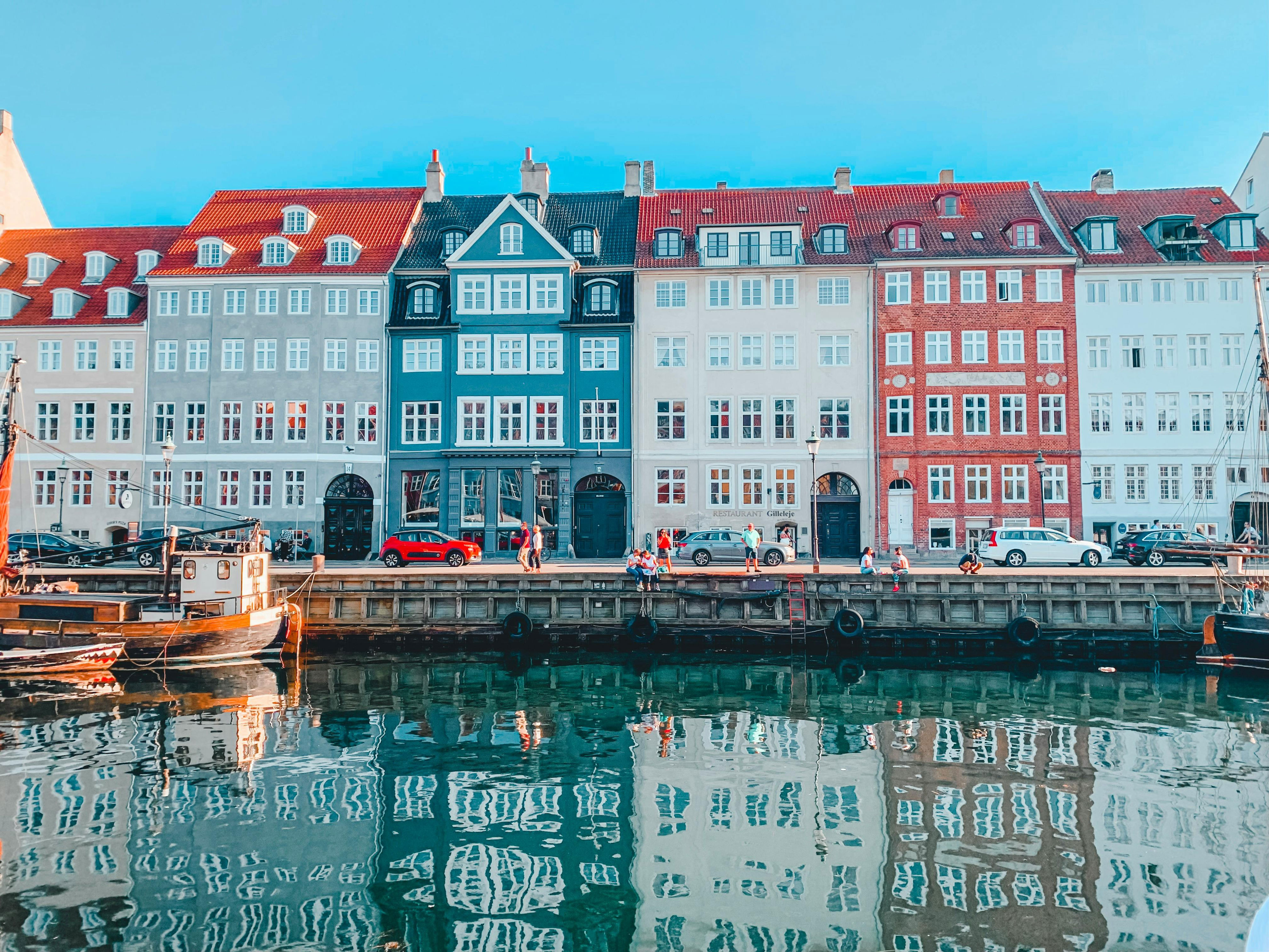 <h3>Copenhagen, Denmark</h3><p>Within the past few years, Denmark's capital has emerged from under-the-radar locale to a must-see destination for in-the-know travelers. Copenhagen was named one of the <a href="https://www.brit.co/happiest-cities-in-the-world/"><strong>happiest cities in the world</strong></a> and in our expert opinion, it's also one of the most beautiful, thanks to Nyhavn, the famous 17th century harbor. First time visitors should stay downtown in Indre By, which is centrally located to fun activities and some of the most picturesque parts of the city. We recommend Hotel Bethel or The Socialist, for a more luxe hotel option. Stroll down the waterway and explore the medieval architecture, like Rosenborg Castle. Wander into Tivoli Gardens, a small amusement park with aesthetic gardens. Embrace the playfulness of Scandi Girl style, by supporting CPH-based designers like <strong><a href="https://fave.co/3xJZKyS">Saks Potts</a></strong> and <strong><a href="https://fave.co/3W9HpoM">Ganni</a></strong>.</p>