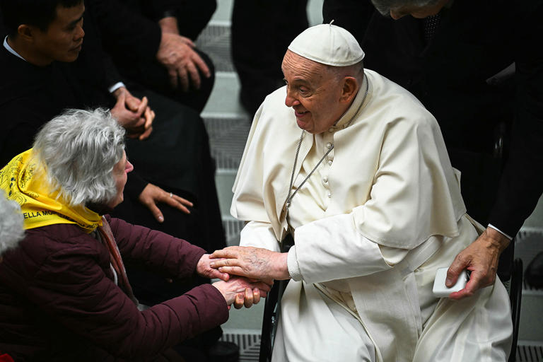 Pope Francis greets a worshipper during his audience with pilgrims from the cities of Cesena, Sarsina, Tivoli, Savona and Imola at Paul VI hall at the Vatican on April 20, 2024.
