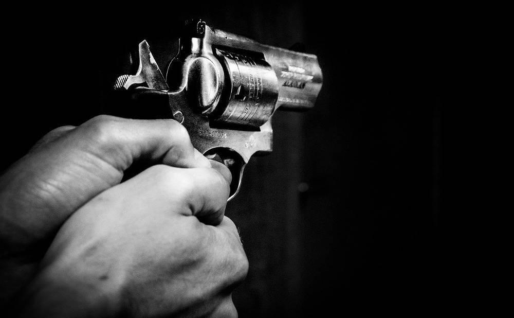 un policier menace son fils avec une arme pour qu'il fasse ses devoirs