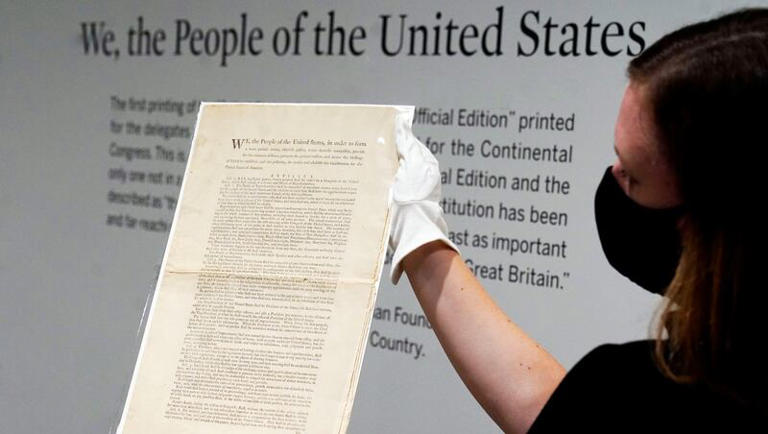 Ella Hall, a specialist in books and manuscripts at Sotheby's, in New York, holds a 1787 printed copy of the U.S. Constitution, Friday, Sept. 17, 2021.