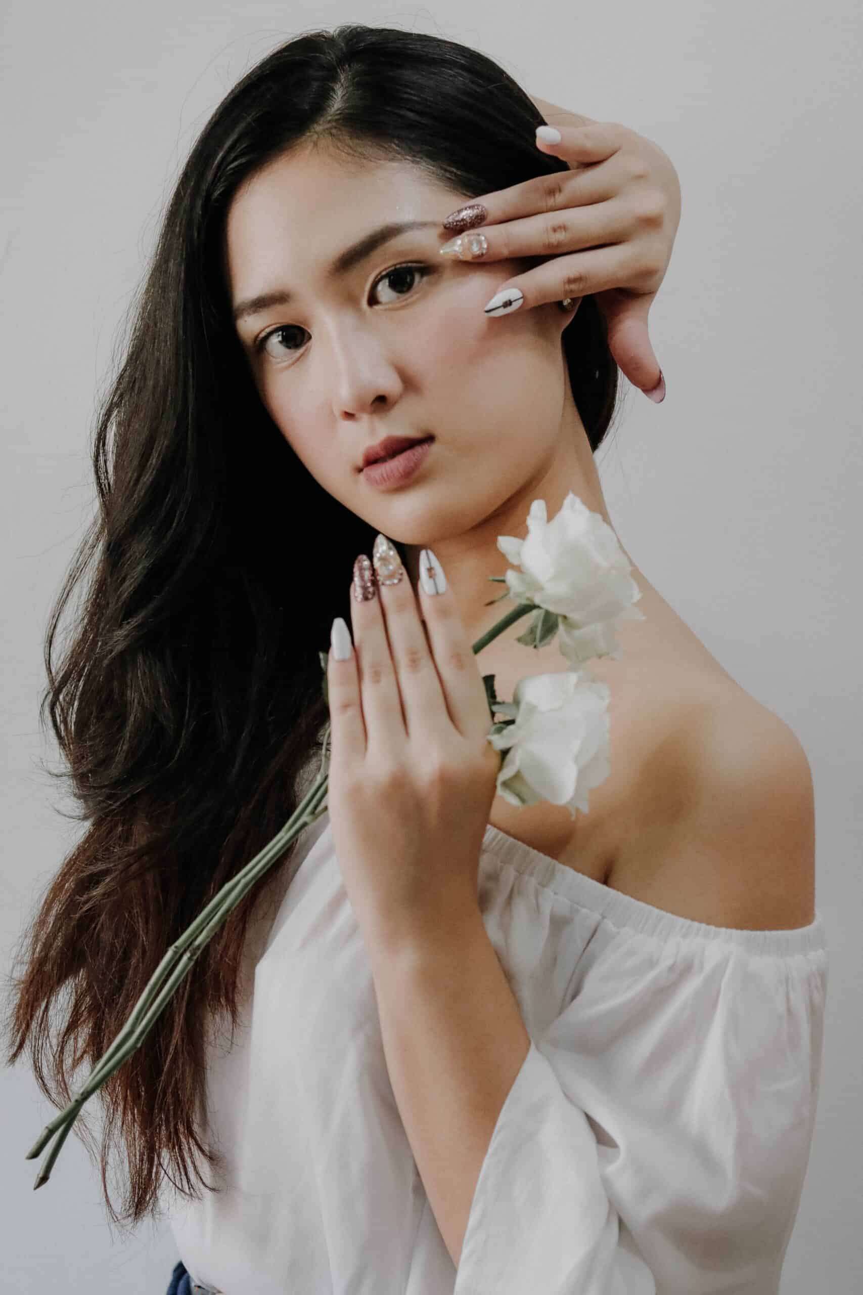 https://www.pexels.com/photo/woman-wearing-white-off-shoulder-blouse-holding-white-rose-flower-while-touching-her-hair-3375235/