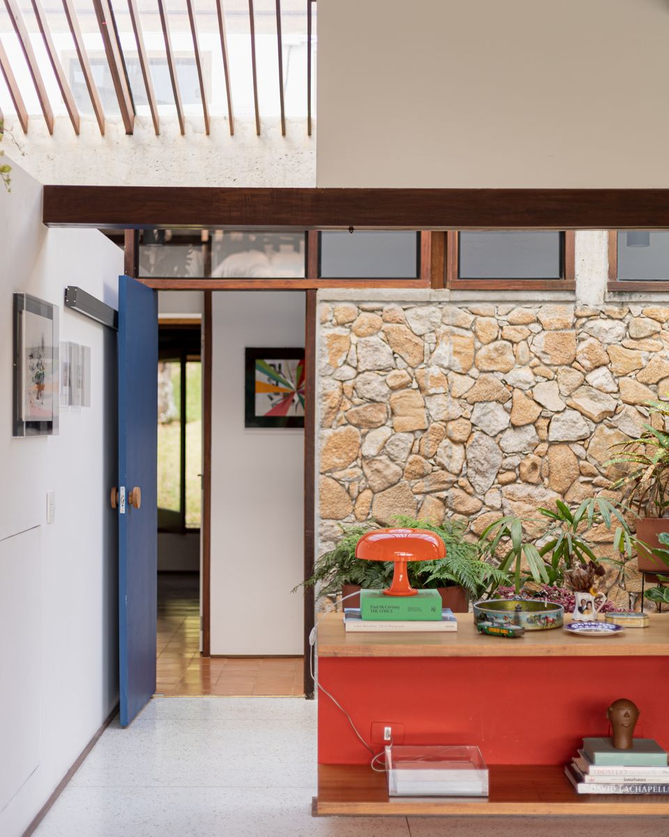 una casa moderna con un salón abierto al jardín, techos de madera, espacios diáfanos y mucho arte
