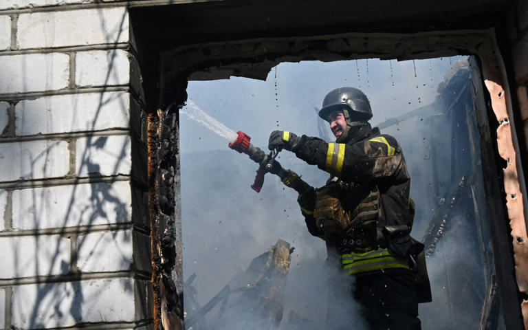 A firefighter at work in Kharkiv after a guided bomb explosion - SERGEY BOBOK/AFP