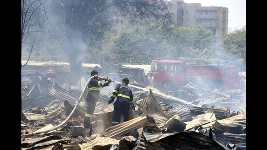 Firefighters trying to douse a fire that gutted 300 shanties in a slum at Saraswati Kunj near Sector-53 in Gurugram on Friday.