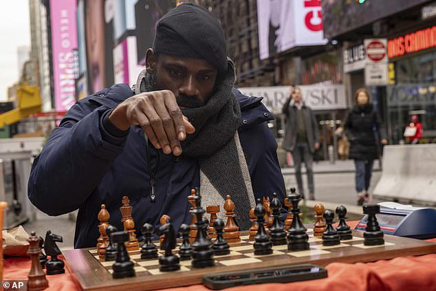 Tunde Onakoya, 29, broke a world chess marathon record by playing for 60 hours straight (pictured: Tunde attempts the record in New York's Time Square on April 17)