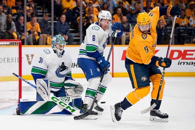 Nashville Predators left wing Filip Forsberg (9) looks for the puck next to Vancouver Canucks goaltender Arturs Silovs (31) and right wing Brock Boeser (6) during the first period in Game 6 of an NHL hockey Stanley Cup first-round playoff series game at Bridgestone Arena in Nashville, Tenn., Friday, May 3, 2024.