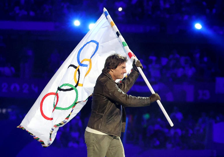 Paris 2024 Olympics - Ceremonies - Paris 2024 Closing Ceremony - Stade de France, Saint-Denis, France - August 11, 2024. Actor Tom Cruise holds the Olympic flag during the closing ceremony. REUTERS/Phil Noble   TPX IMAGES OF THE DAY