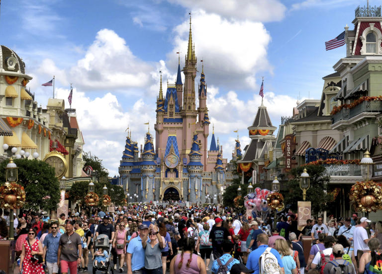 Crowds fill Main Street USA in front of Cinderella Castle at the Magic Kingdom on the 50th anniversary of Walt Disney World, in Lake Buena Vista, Fla., Friday, Oct. 1, 2021. Each guest received an anniversary keepsake poster and a commemorative park map. The Magic Kingdom opened 50 years to the day in 1971.