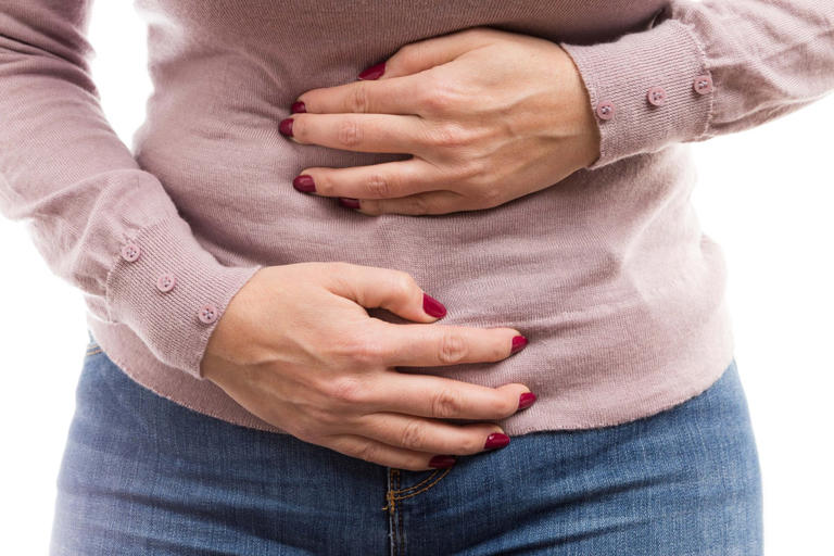 Woman holding her tummy as painful abdomen problem or constipation cramps concept