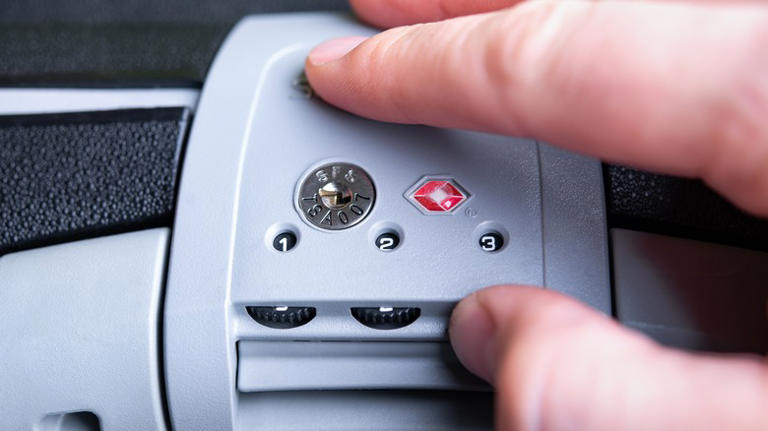 Traveler's fingers setting a TSA lock