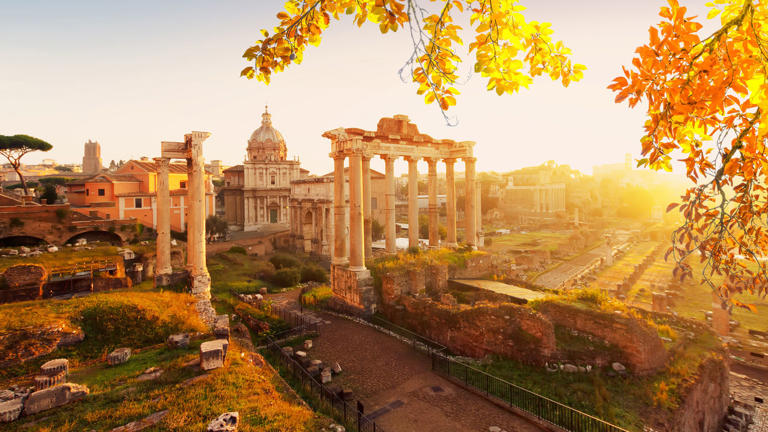 Roman ruins with cityscape of Rome with warm sunrire light, Italy af fall