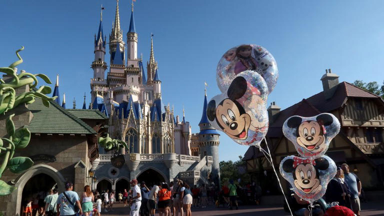 Mickey Mouse and Minnie Mouse balloons fly in front of Cinderella's Castle at the Magic Kingdom Park at Walt Disney World.