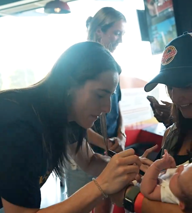 Clark signs the baby’s onesie. @IndianaFever/X