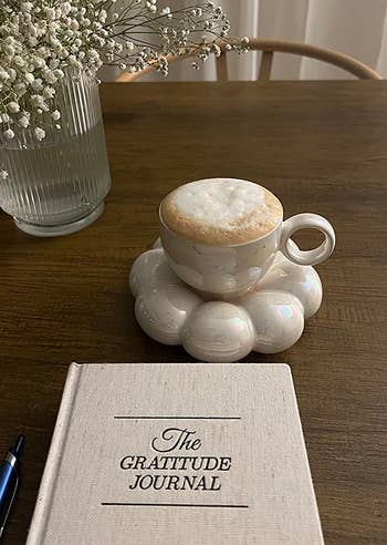 a white cup on a matching white sunflower coaster