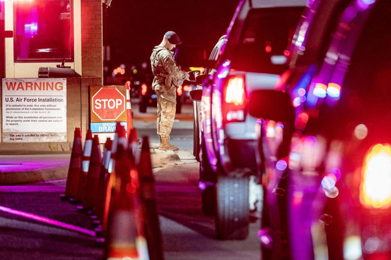 An Air Force security guard is shown checking authorizations at the gate of Joint Base San Antonio-Lackland in Texas on June 26. Authorities said the gate was closed on Saturday after guards exchanged fire with unknown assailants shooting from a nearby road. U.S. Air Force