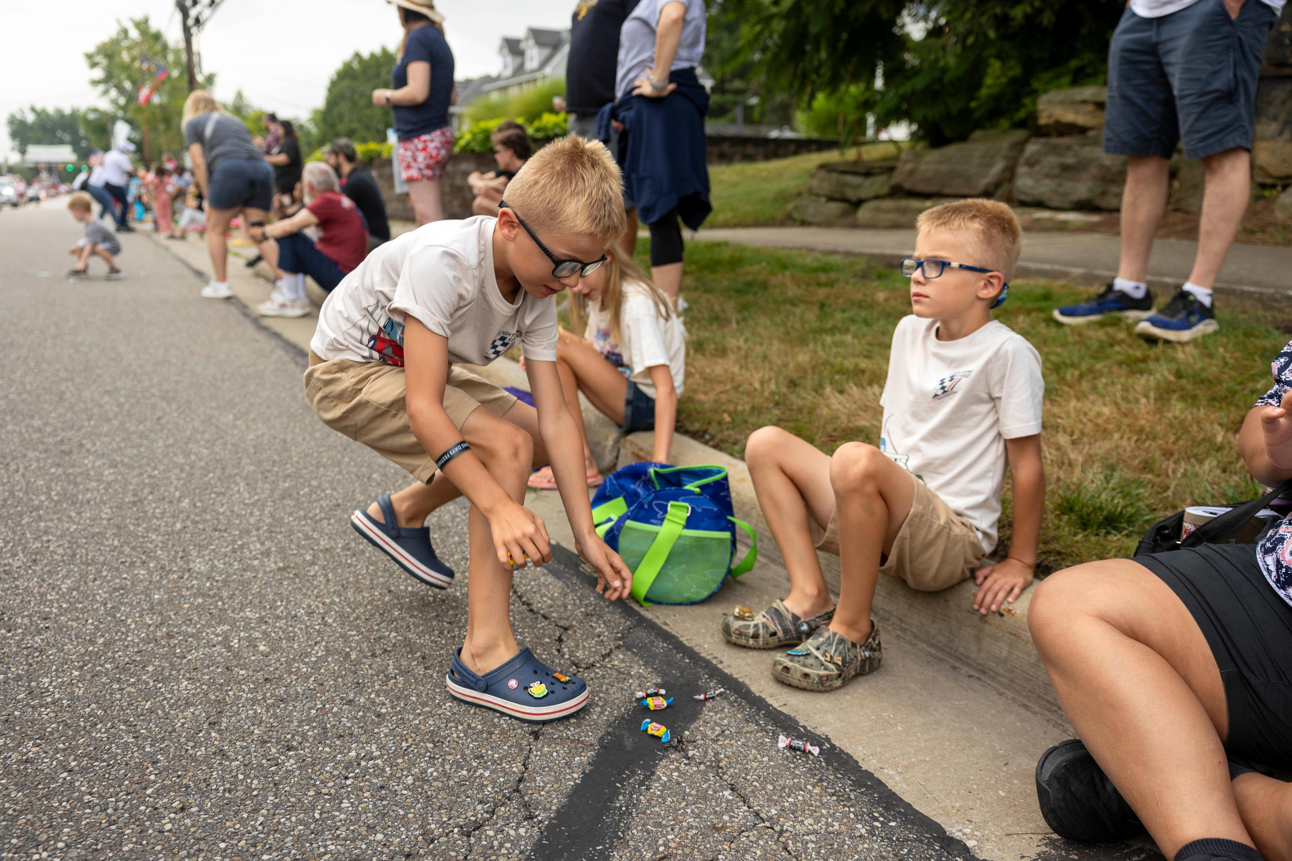 Seven-year-old twin brothers Lee and Reid Schwartz from Niagara Falls, New York, collect candy during the Twins Days Festival’s Double Take Parade Saturday, August 3, 2024 in Twinsburg, OhioH.