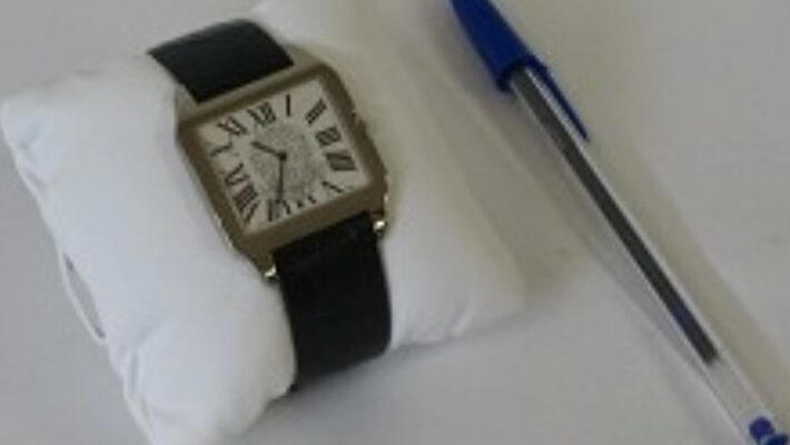 Relógio de pulso da marca Cartier, com pulseira em couro preto, fecho em ouro branco 18K e prata 750. Coroa arrematada com uma padra azul lapidada, safira. Foto: Reprodução