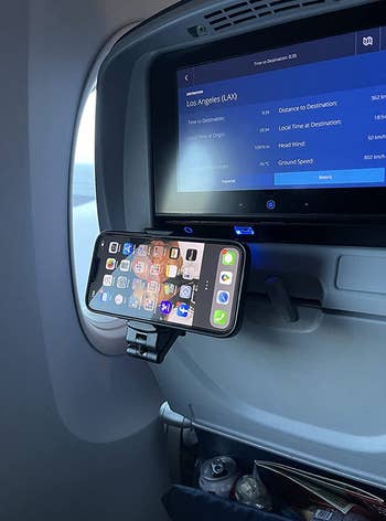 reviewer photo of the phone mount attached to their stowed away tray table