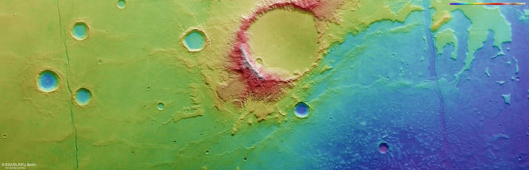 This colour-coded topographic image shows a region of Mars known as Caralis Chaos, where copious water is thought to have once existed in the form of an ancient lake. It was created from data collected by ESA’s Mars Express on 1 January 2024 (orbit 25235) and is based on a digital terrain model of the region, from which the topography of the landscape can be derived. Lower parts of the surface are shown in blues and purples, while higher altitude regions show up in whites and reds, as indicated on the scale to the top right. North is to the right. The ground resolution is approximately 15 m/pixel and the image is centred at about 38°S/177°E. Credit: ESA/DLR/FU Berlin