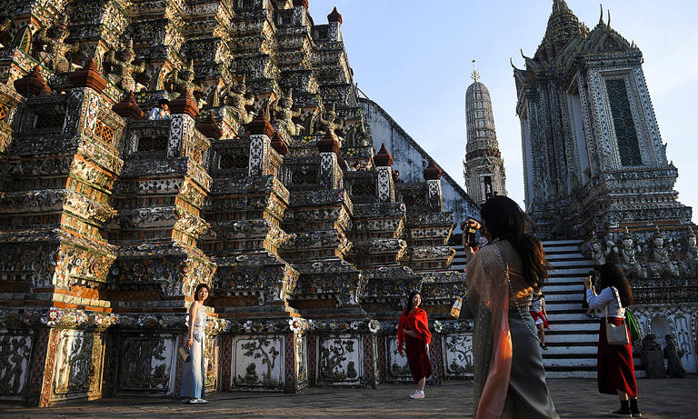 Tourists dressed in traditional Thai costumes visit Wat Arun temple in Bangkok, Thailand, Jan. 18, 2023. Photo by Reuters