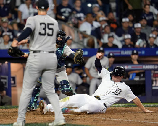 Clay Holmes (35) watches as the Tigers’ Colt Keith (r.) slides into home during the Yankees’ loss on Aug. 18, 2024. AP