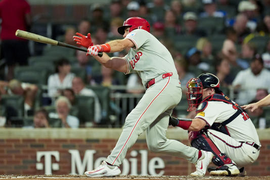 Philadelphia Phillies catcher J.T. Realmuto (10) hits an RBI-single against the Atlanta Braves during the fourth inning of a baseball game, Tuesday, Aug. 20, 2024, in Atlanta. (AP Photo/Mike Stewart)